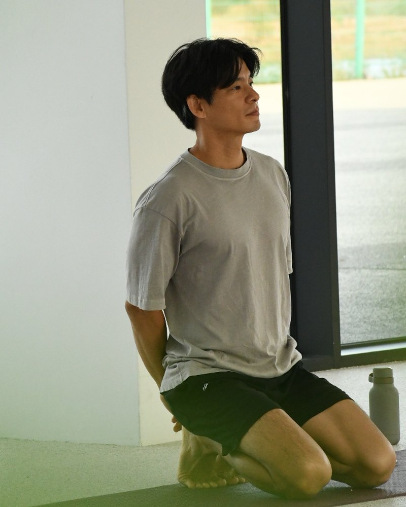 요가 매트에 무릎 꿇고 앉아 있는 김진혁 강사